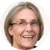 headshot of smiling open mouthed woman with glasses